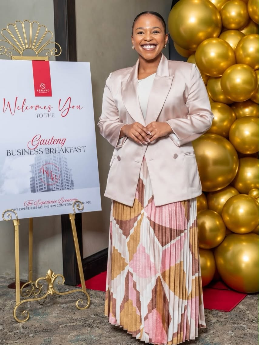 Nandisa Ngubelanga at the Gauteng Business Breakfast beside the event welcome sign